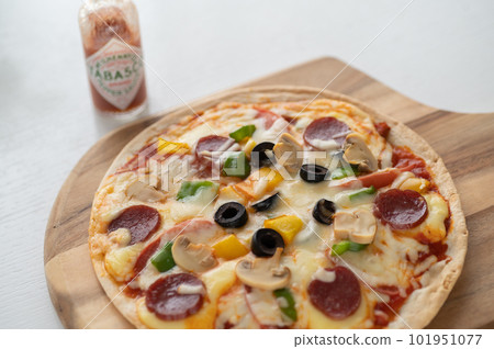 Milanese-style pizza with a thin crust Milanese-style pizza with a thin crust 101951077