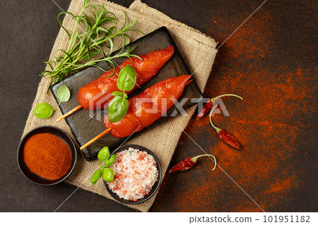 Fresh raw marinated chicken meat skewers iner fillet with fresh herbs on a black background.Top view.Copy space.Chicken fillet inner skewers.Food concept.Food for retail.Ogranic food,healthy eating. Fresh raw marinated chicken meat skewers iner fillet with fresh herbs on a black background.Top view.Copy space.Chicken fillet inner skewers.Food concept.Food for retail.Ogranic food,healthy eating. 101951182
