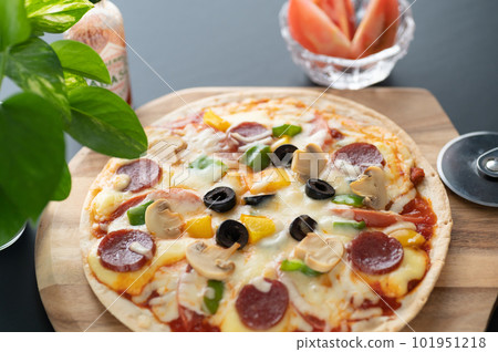 Milanese-style pizza with a thin crust Milanese-style pizza with a thin crust 101951218