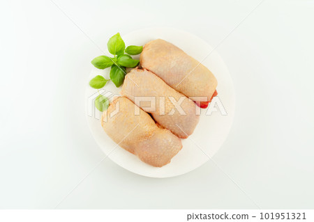 Food concept.Top view.Chicken leg meat.Raw fresh chicken leg meat with skin and with fresh herbs on a white background.Copy space.Food for retail.Procurement for designers.Ogranic food,healthy eating. Food concept.Top view.Chicken leg meat.Raw fresh chicken leg meat with skin and with fresh herbs on a white background.Copy space.Food for retail.Procurement for designers.Ogranic food,healthy eating. 101951321