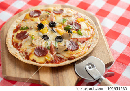 Milanese-style pizza with a thin crust Milanese-style pizza with a thin crust 101951383