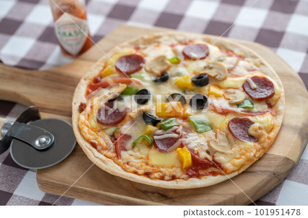 Milanese-style pizza with a thin crust Milanese-style pizza with a thin crust 101951478