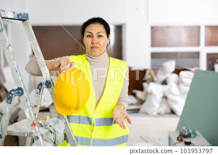 Tired woman builder in safety helmet and vest 101953797