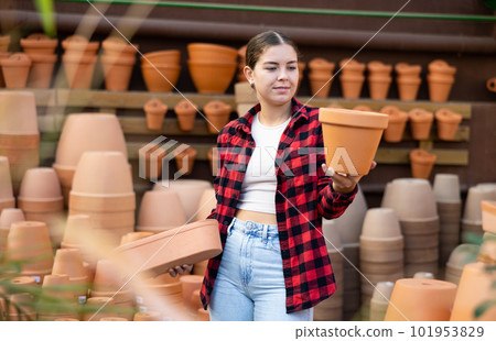 Young girl choosing pots for growing houseplants in gardening store 101953829