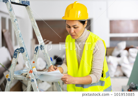 Woman in overalls signs an act of acceptance of completed work Woman in overalls signs an act of acceptance of completed work 101953885