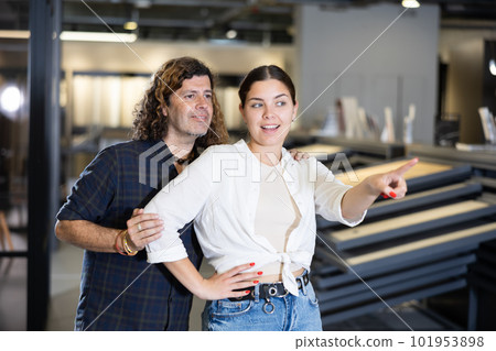 Woman and man points his hand at something in hardware store Woman and man points his hand at something in hardware store 101953898