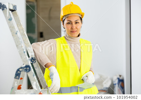 Portrait of female house painter with tools in renovated room 101954002