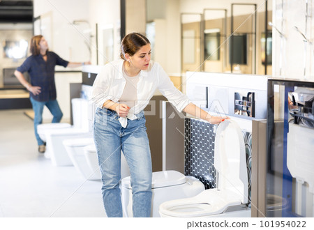 Woman looking to buy new toilet in harware store 101954022