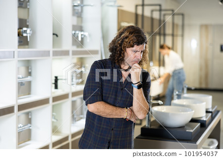 in plumbing department, man thought about choosing suitable bathroom for new apartment in plumbing department, man thought about choosing suitable bathroom for new apartment 101954037