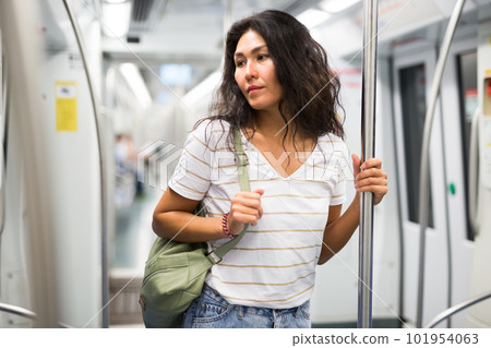 Woman standing in subway train Woman standing in subway train 101954063
