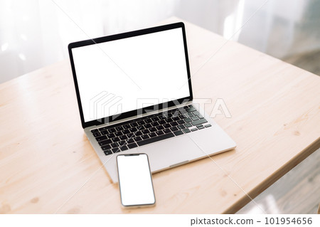 Smartphone and laptop with blank screens for text or advertising on wooden table Smartphone and laptop with blank screens for text or advertising on wooden table 101954656