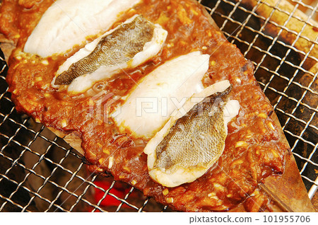 Grilling fish on a charcoal brazier Grilling fish on a charcoal brazier 101955706