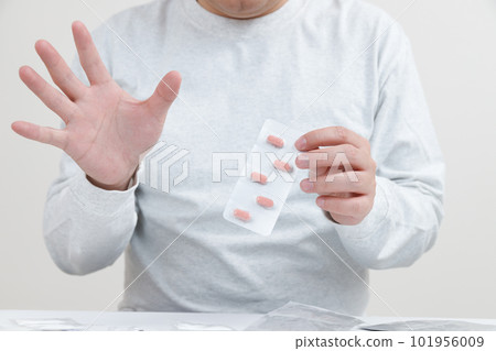 A man who refuses to take medication. holding a pill A man who refuses to take medication. holding a pill 101956009