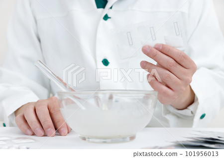 有粉碎說明的藥劑師。一隻手在杵中混合藥物 101956013