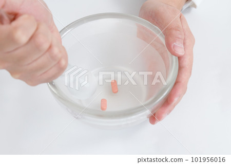 pharmacist with crushing instructions. Tablets in a mortar and crushed with a pestle 101956016