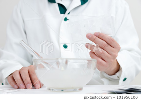 pharmacist with crushing instructions. A hand mixing medicine in a pestle 101956100