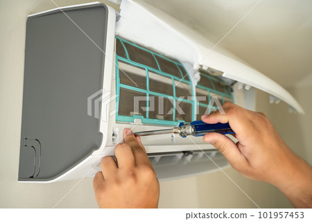 Male professional technician fixing An electrician repairs an air conditioner indoors. removing air filter repairing hot temperatures 101957453