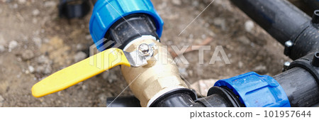 Elbow fitting of pvc pipes at bend with yellow faucet 101957644