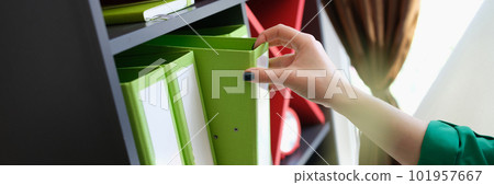 Female hands taking off green folder with documents 101957667
