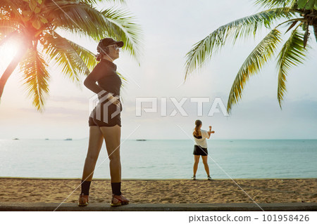 two woman stretching warm up before exercise at sea beach 101958426