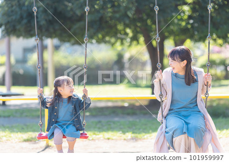 Parent and child playing in the park 101959997