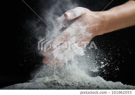 Female hands sift flour with a metal sieve on a black background. Female hands sift flour with a metal sieve on a black background. 101962055