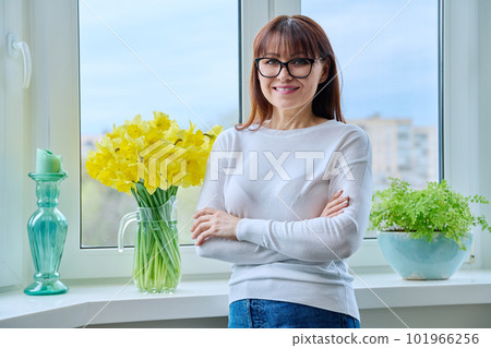 Middle age smiling woman looking at camera, near window at home 101966256