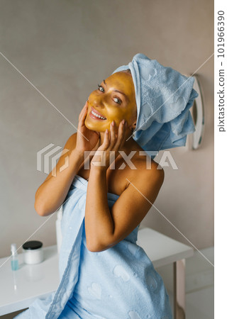 Attractive young adult woman apply face cream, beautiful healthy lady wrapped in towels, apply moisturizing lifting-nourishing day cream to soft moisturized skin 101966390