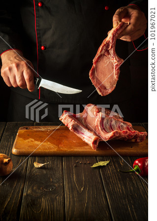 Cutting raw ribs with butcher hands on kitchen cutting board. Barbecue grill idea Cutting raw ribs with butcher hands on kitchen cutting board. Barbecue grill idea 101967021