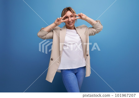 close-up of a positive kind blonde young woman in a beige jacket with emotions on her face in the close-up of a positive kind blonde young woman in a beige jacket with emotions on her face in the 101967207