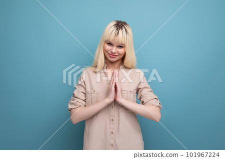 pretty cheerful young blond woman flirting on blue background with copy space 101967224