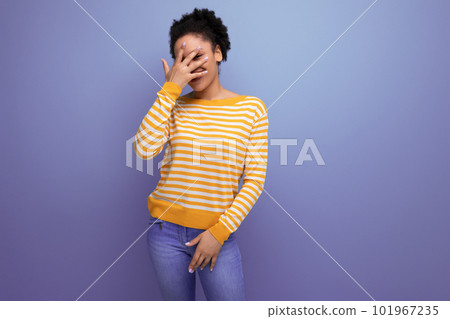 portrait latin young woman with a ponytail of afro hair covers her face with her hand portrait latin young woman with a ponytail of afro hair covers her face with her hand 101967235