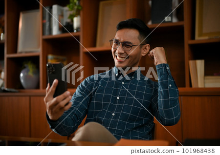 Happy Asian businesswoman celebrating after receiving a good email or sms. 101968438