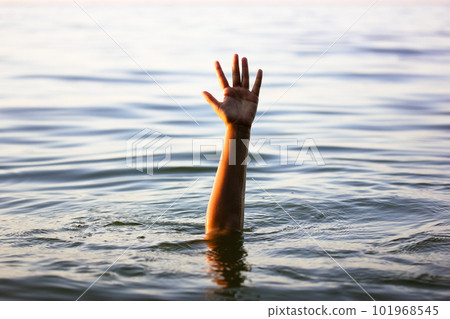 A hand peeks out from under a water. A drowning person, victim needs help. SOS. A hand peeks out from under a water. A drowning person, victim needs help. SOS. 101968545