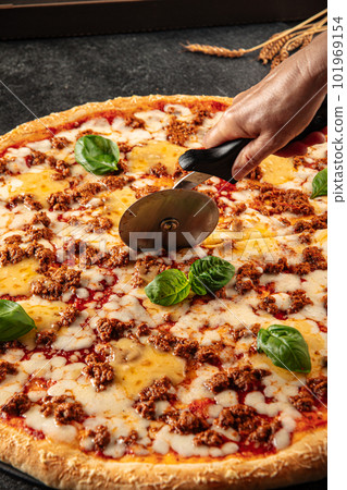Cutting cheddar and beef pizza with special knife Cutting cheddar and beef pizza with special knife 101969154
