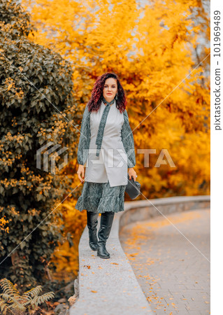 A woman walks outdoors in autumn, enjoys the autumn weather. A woman walks outdoors in autumn, enjoys the autumn weather. 101969489