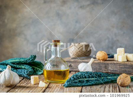 Ingredients for homemade kale - kale leaves, walnuts, parmesan, garlic and olive oil on wooden surface with grey background  101969925