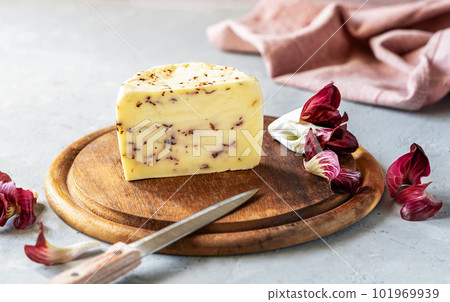 Italian traditional soft cheese Caciotta with radicchio on wooden cutting board, grey and rose background, rose napkin, fresh radish Italian traditional soft cheese Caciotta with radicchio on wooden cutting board, grey and rose background, rose napkin, fresh radish 101969939