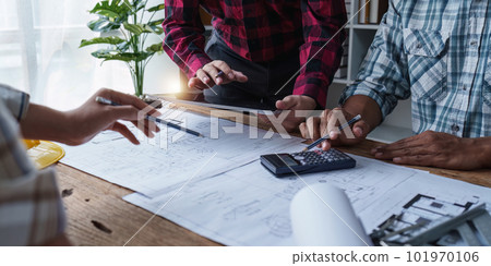 Architect and Engineer working with blueprints for architectural plan, engineer sketching a construction project, green energy concept 101970106