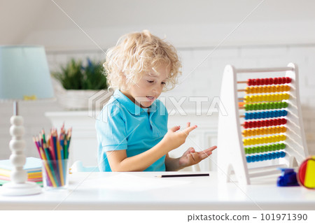 Child with abacus doing homework after school. Child with abacus doing homework after school. 101971390