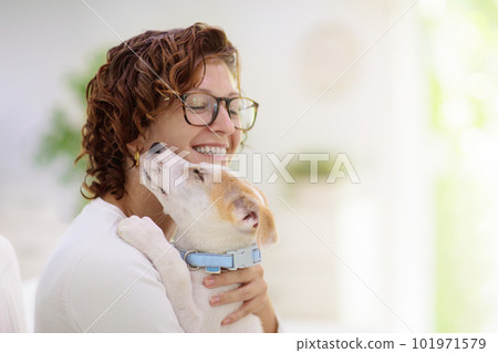 Woman with puppy. Curly girl holding little dog. Woman with puppy. Curly girl holding little dog. 101971579
