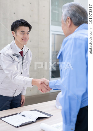 Men in work clothes shaking hands 101973817