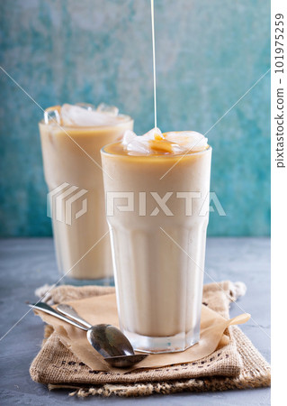Iced coffee with milk in tall glasses Iced coffee with milk in tall glasses 101975259