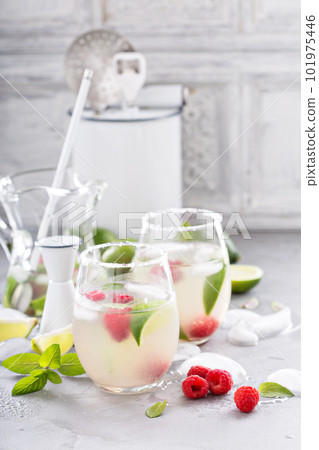 Cold summer cocktail with limes and raspberry Cold summer cocktail with limes and raspberry 101975446