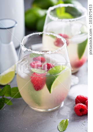 Cold summer cocktail with limes and raspberry 101975453