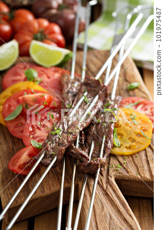 Flank steak on skewers with tomatoes 101975487