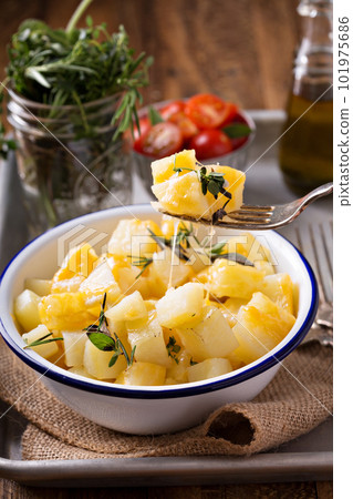 Potato with cheese and herbs prepared on a grill 101975686
