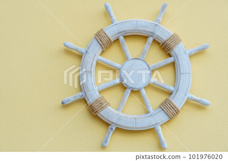 White marine steering wheel on light background. Sea voyages and adventures. Vacation on yacht. Promotional postcards. White marine steering wheel on light background. Sea voyages and adventures. Vacation on yacht. Promotional postcards. 101976020
