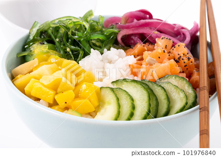 Poke bowl with rice, salmon,cucumber,mango,onion,wakame salad, poppy seeds ands sunflowers seeds isolated on white background 101976840