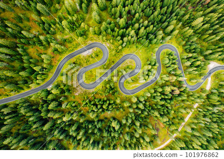 Vehicles traversing the renowned Snake Road, a picturesque driveway amidst the verdant forests of the famous Giau Pass. Vehicles traversing the renowned Snake Road, a picturesque driveway amidst the verdant forests of the famous Giau Pass. 101976862